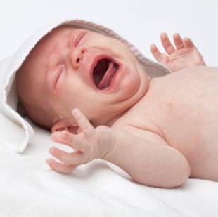 Portrait of unattended newborn crying.